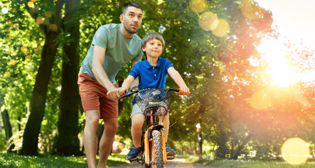 Navigating stepfatherhood - A stepdad teaching his stepson how to ride a bike.