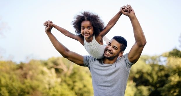 Tips for stepdads raising stepdaughters- A stepdad playing with his child on a field