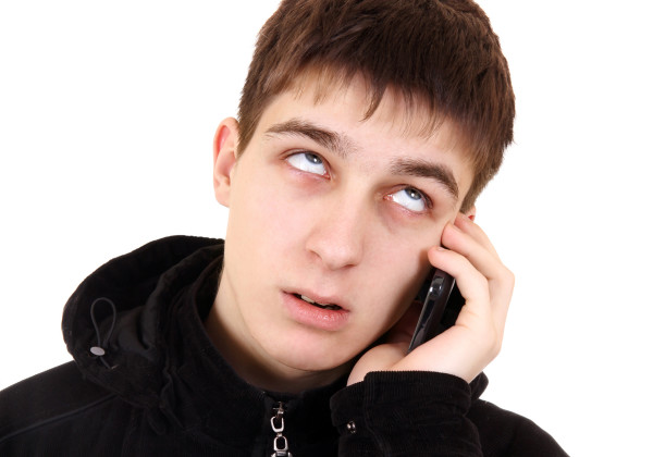 Annoyed Teenager with Cellphone Isolated on the White Background