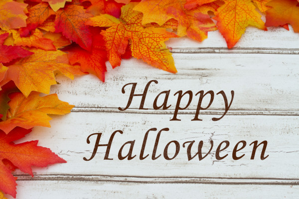 Happy Halloween written on grunge wood background with Autumn Leaves