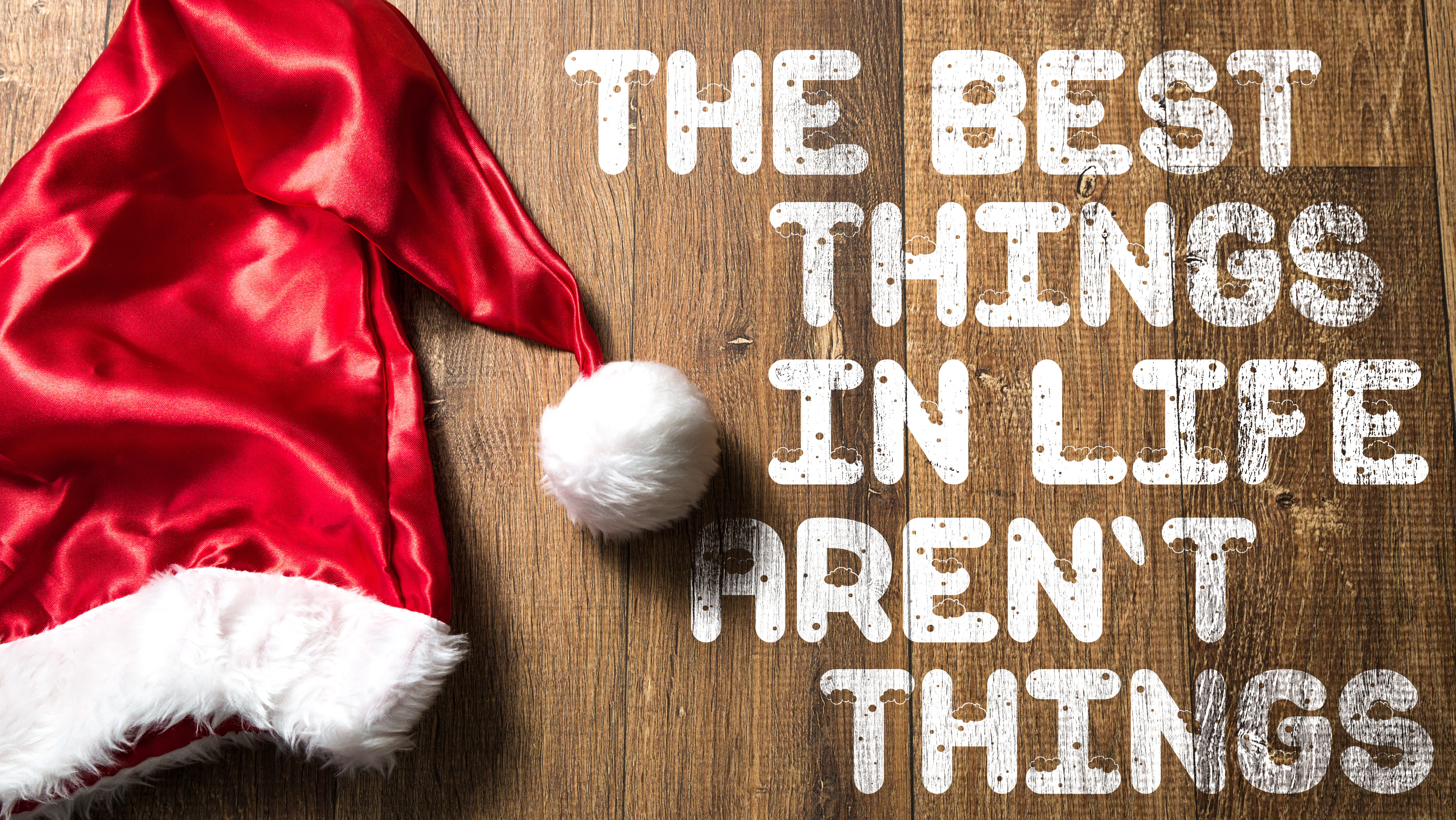 The Best Things In Life Aren't Things written on wooden with Santa Hat