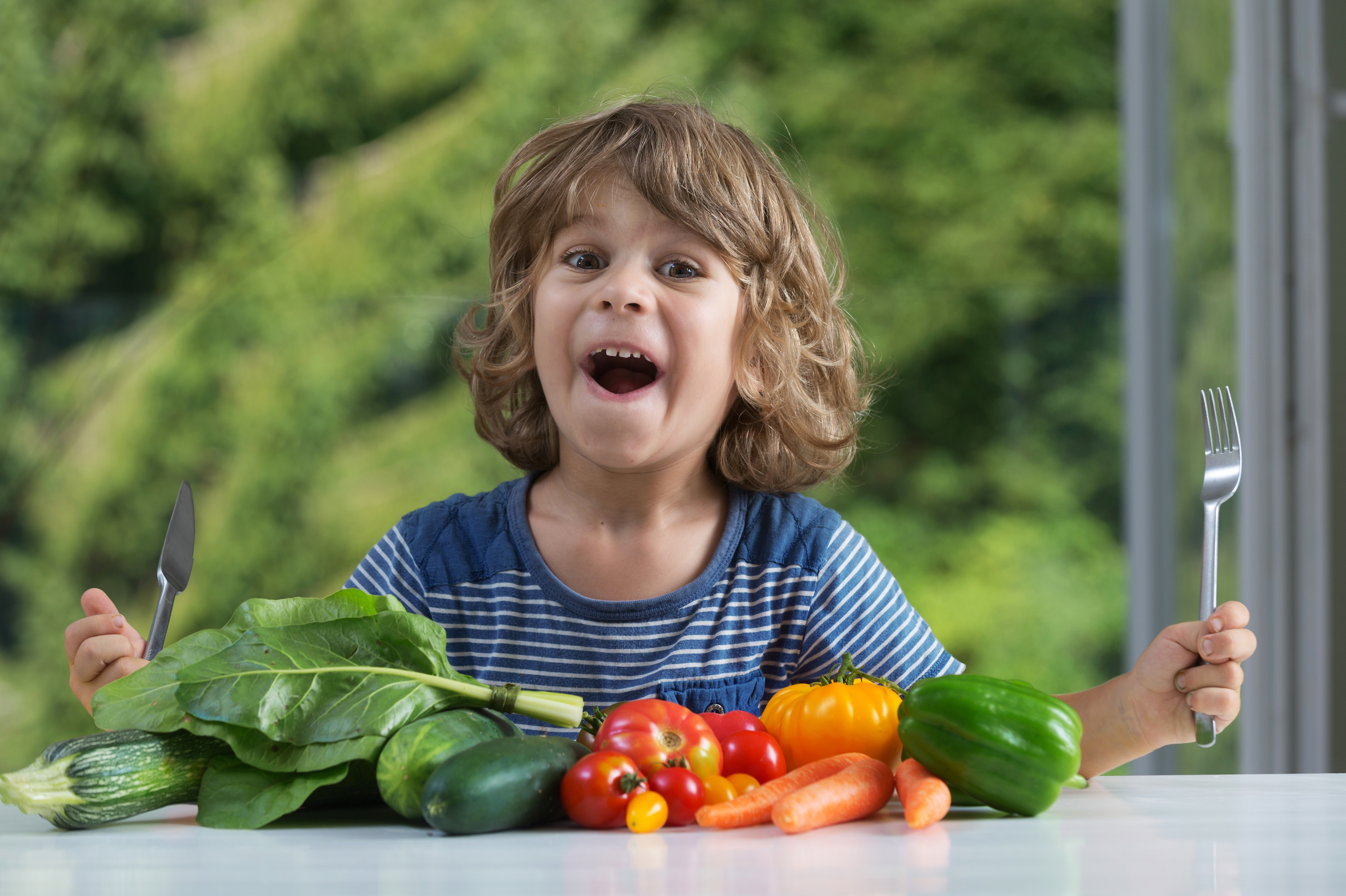 Nuture healthy lifestyle habits in children - Cute little boy sitting at the table excited about vegetable meal, bad or good eating habits, nutrition and healthy eating, showing emotions concept