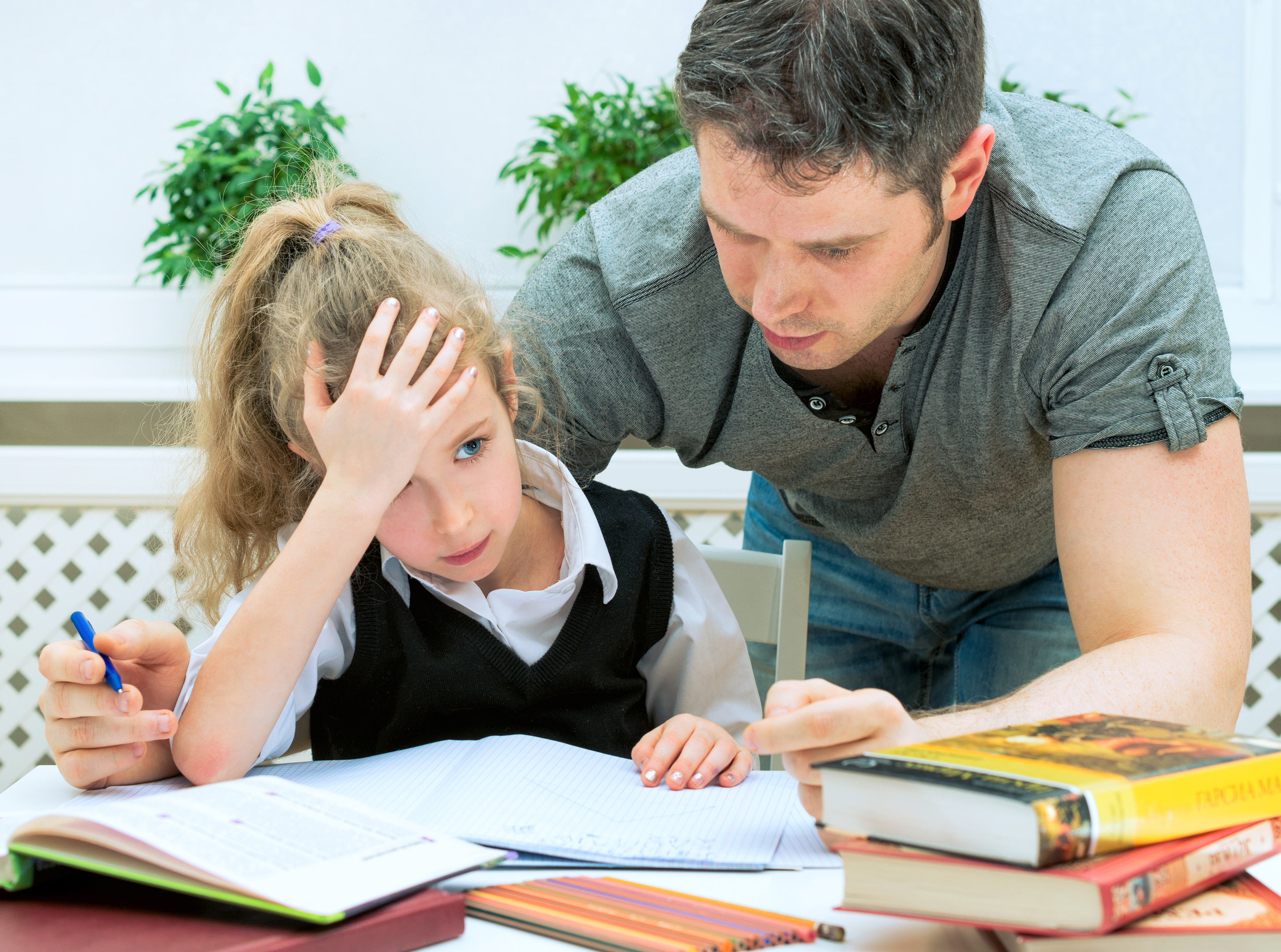 Tips to help your kids study. Father helping daughter with homework at home.