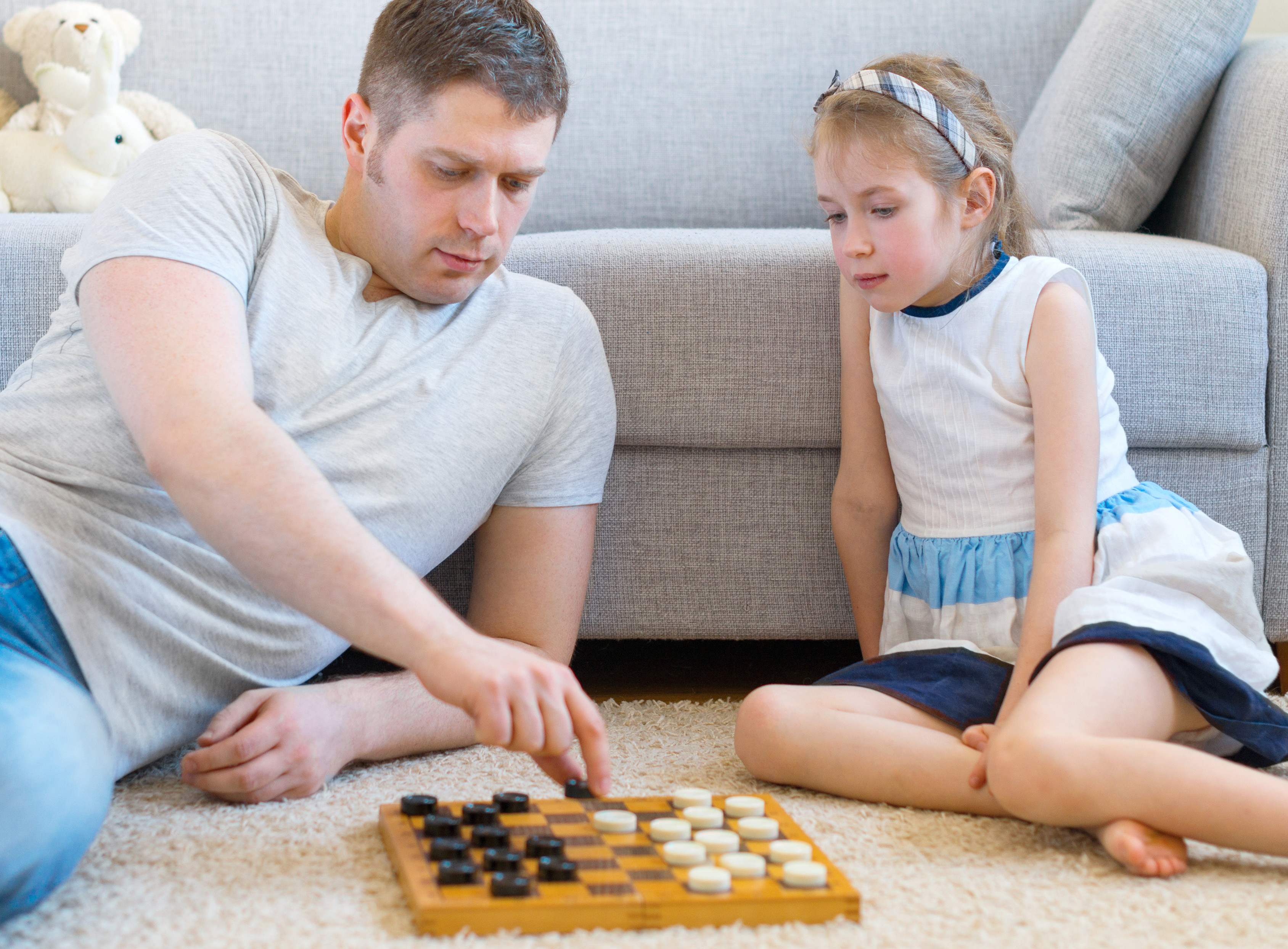 Stepdaughter and stepfather playing checkers.