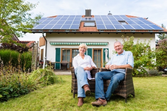 green updates add value to your real estate - image of couple sitting in their backyard of home with solar panels