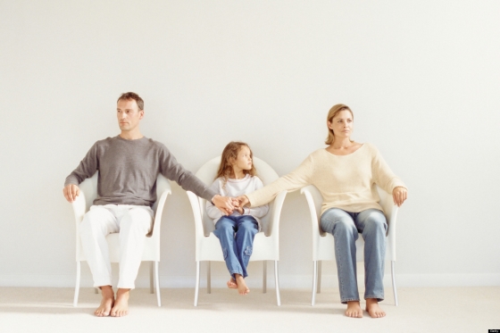talk with your child about divorce - a young girl sitting between her two estranged parents