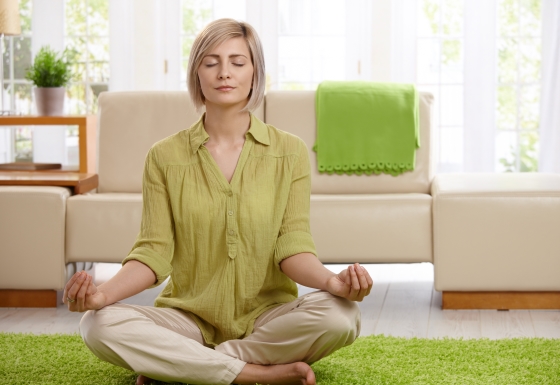 creating your home meditation space - a woman meditating on a plush carpet