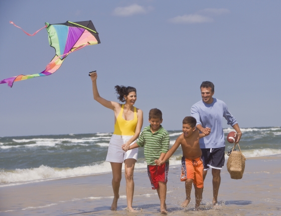 late summer family outing ideas - a hispanic stepfamily enjoying a day at the beach