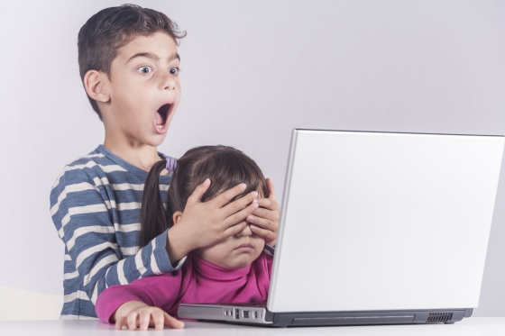 Kids safe on the web - brother shielding his younger sister's eyes from viewing inappropriate material on the web