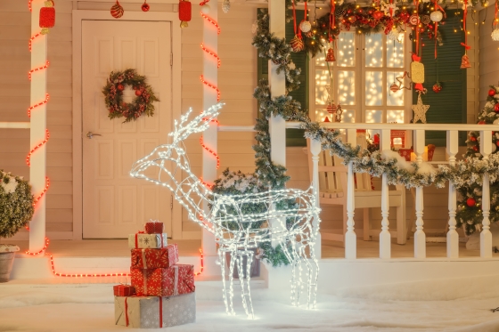 fabulous outdoor Christmas decorations - Vintage Christmas decorated house with illuminated deer in front of the door, gift boxes,
