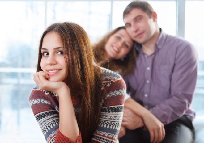 preparing your child to becoming a teen - smiling teenager sitting in front of mom and stepdad