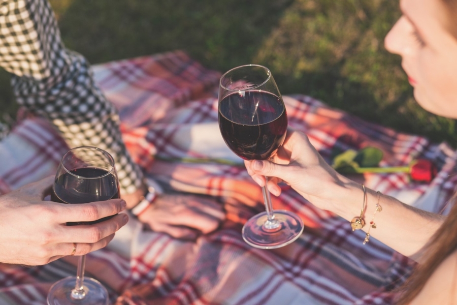 maintaining the romance in your relationship - a couple sharing a glass of red wine at a picnic