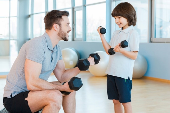get back in shape while spending time with your stepkids - stepdad practicing dumbells with his stepson