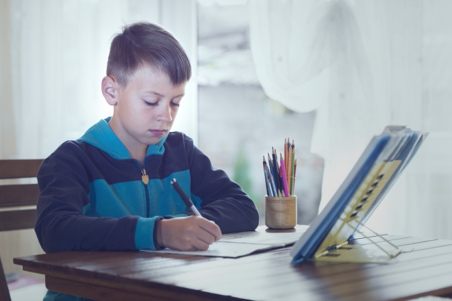 engage your kids in writing - school age boy writing at home