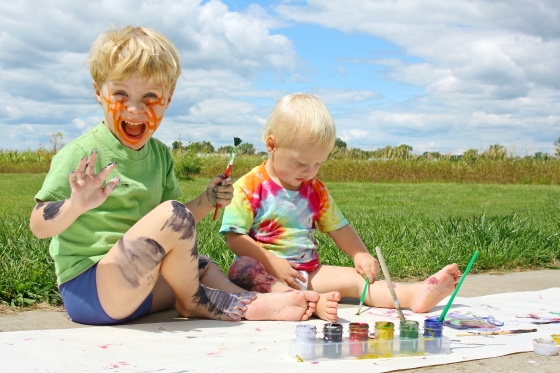 Outdoor Activities To Help Your Kids Develop Motor Skills - two kids having fun painting outdoors