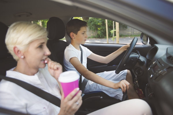 co-parenting when you have a new teen driver - teenage son behind the wheel with his mother coaching