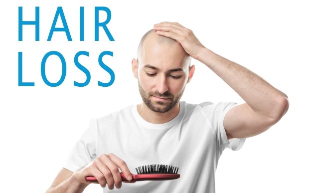 dealing with hair loss - balding man examining his hair brush