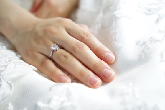 things he needs to know when buying a diamond ring - image of a woman's hand with an engaging ring