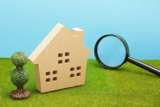property survey don't be caught without one - a picture of a home with a magnifying glass symbolizing inspecting the property