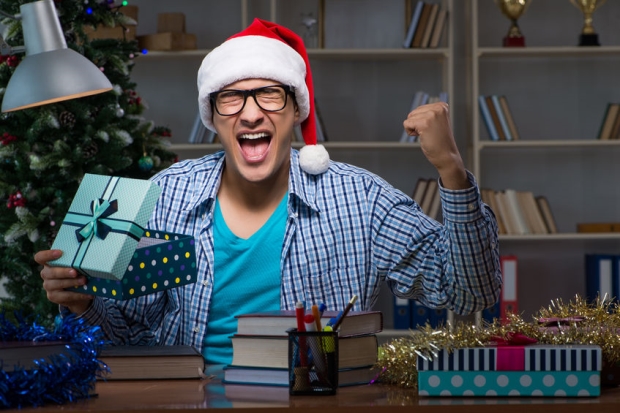 holiday gift guide for your college student - college student excited by his Christmas gift