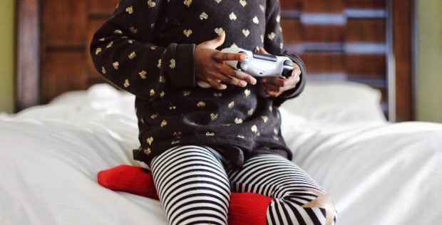 limit video game play during Christmas break -kid in pijamas playing video games
