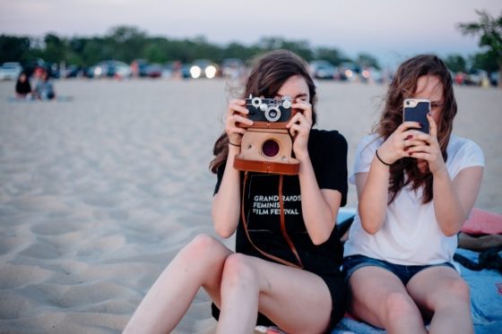 vacation ideas for the entire family - picture of two tweens taking pictures on the beach