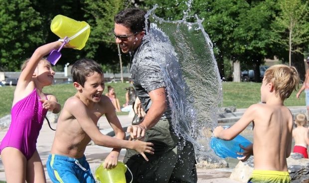 vacaton ideas for the entire family - stepdad and kids involved in water fight