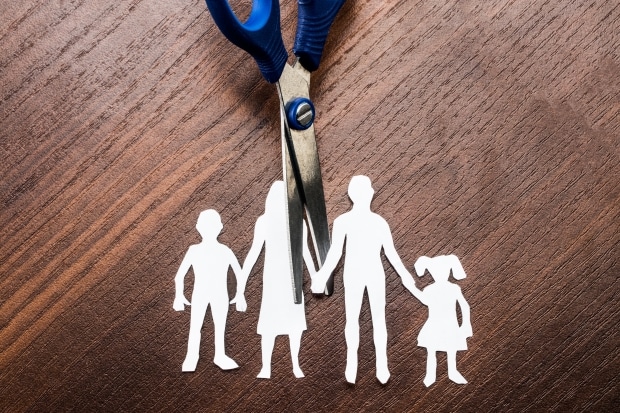 considerations for a dad's custody case - paper cutout of a family of four being cut in the middle leaving each parent with a child