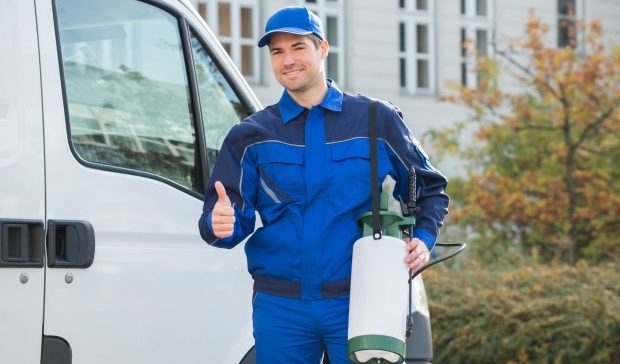 how to select a pest controller - pest control worker standing near van showing thumbs up