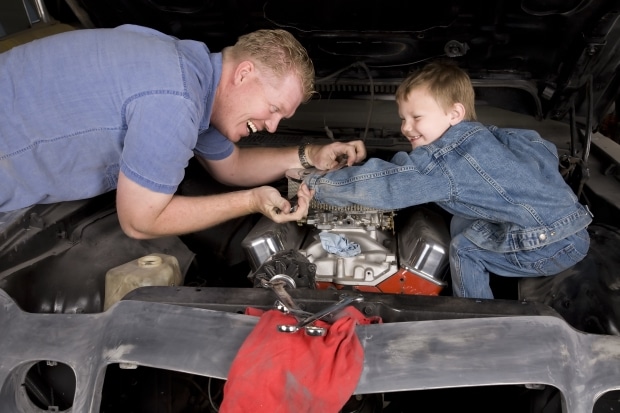 fixing a classic car - father and stepson working on car