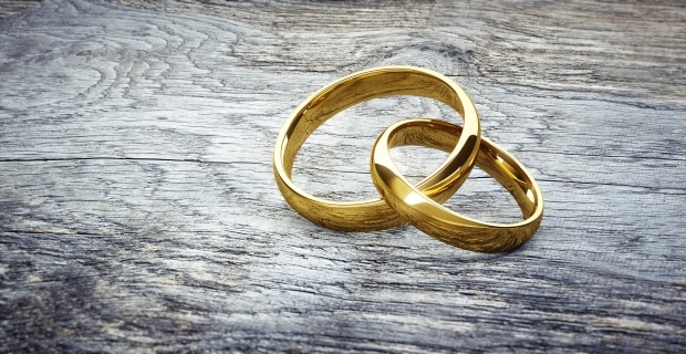 buyer's guide to men's gold wedding bands - picture of two interlocked gold wedding bands