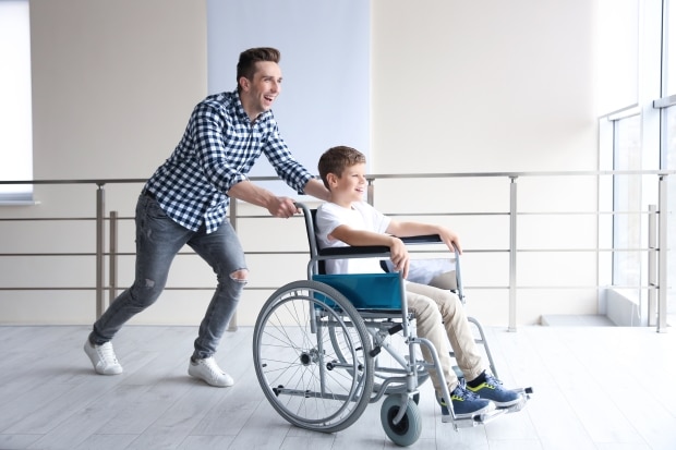 becoming a stepparent to a handicapped child -stepdad pushing handicapped son in wheelchair