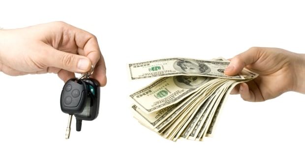 things to know before getting a car loan - one hand with car keys the other hand with money