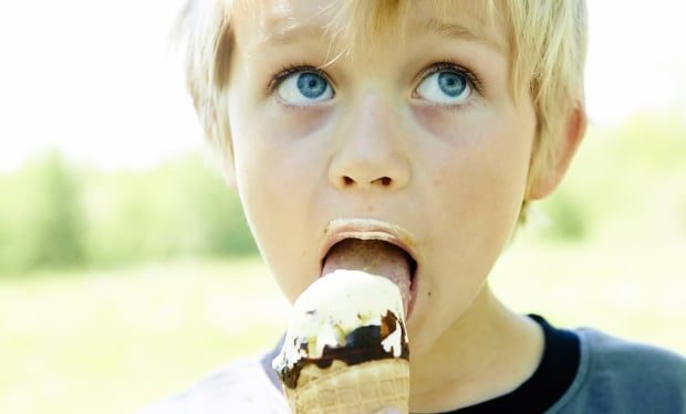 young boy eating ice cream outside
