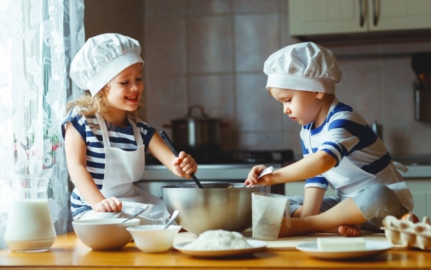 two kids having fun baking cookies