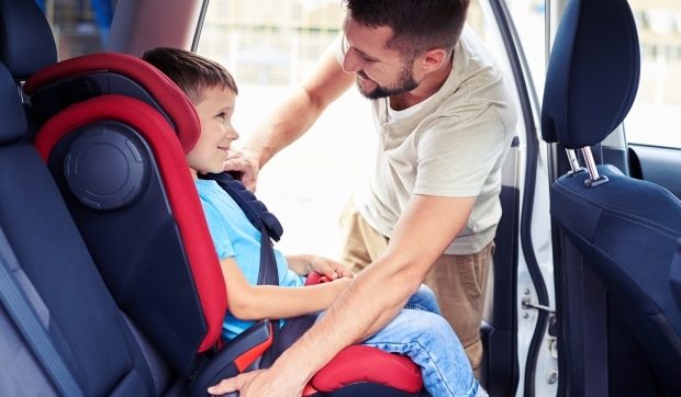 facts about car seat installation-a dad putting his son in a car seat