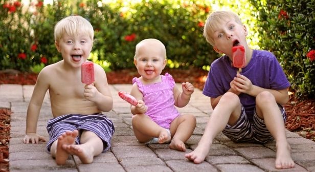 How to make the hot summer comfortable for kids-Three Children Eating Fruit Popsicles Outside on Summer Day