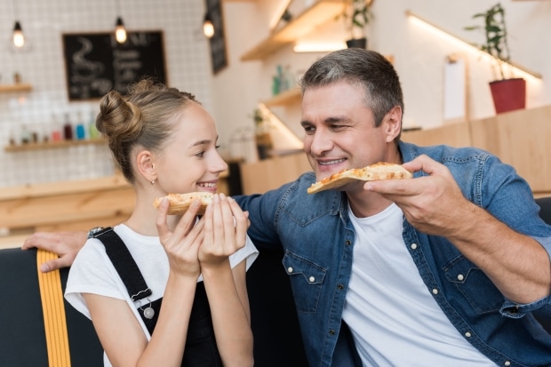 Four vacations your teen will love -stepdad enjoying pizza with stepdaugher