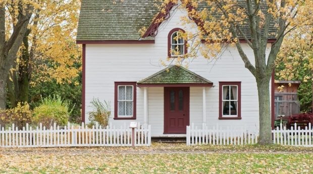 ways to take care of your yard this fall - a house in the fall with leaves in the front yard
