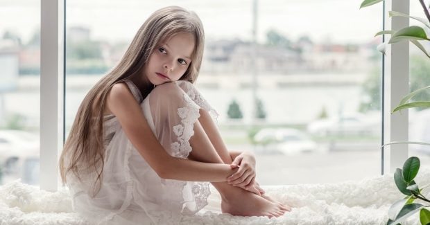 things you can do for your sensitive child - sensitve child sitting alone in front of window