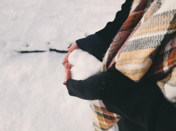woman holding heart shaped piece of snow