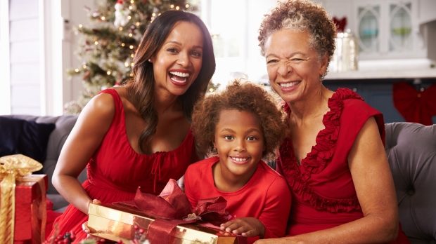 engaging with aging parents -Grandma, mom and granddaughter opening gifts