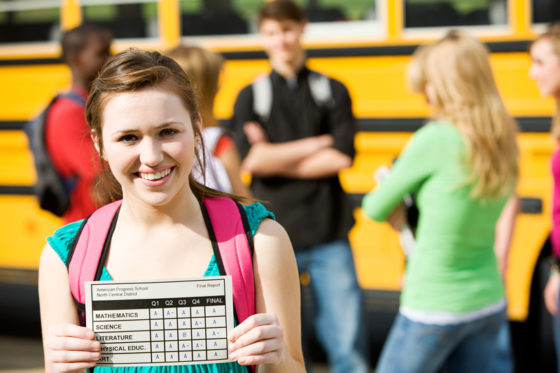ways to help your kids prepare for college - young girl holding up their report card