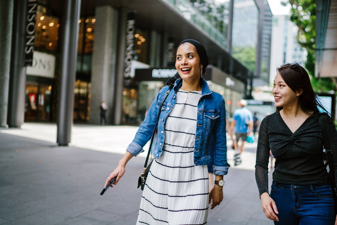 how to save money on dress clothing-two smiling girls walking down the street
