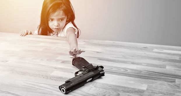 ways to keep your home childproof- a child reaching for a gun