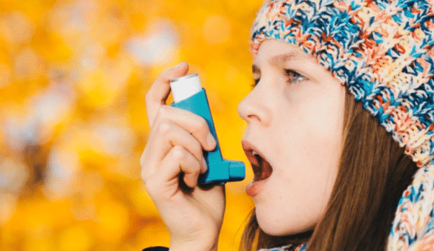 everything stepparents should know about asthma-a girl using an inhaler