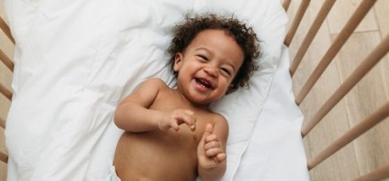 safety check for your kids- a happy baby in a crib