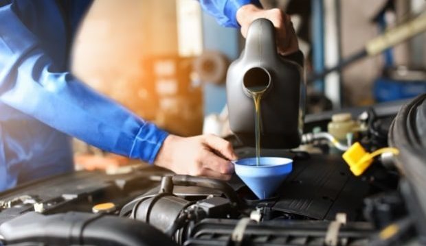 DIY car tasks anyone can learn- a man pouring oil into a car