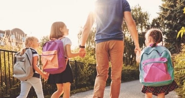Keeping your kids in your life after your divorce- a dad walking his kids to school