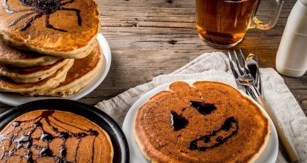 Recipes for kids to get Halloween off to a great start-Pumpkin pie pancakes decorated with chocolate syrup in a traditional style